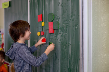 First grade child, learning math, shapes and colors at school