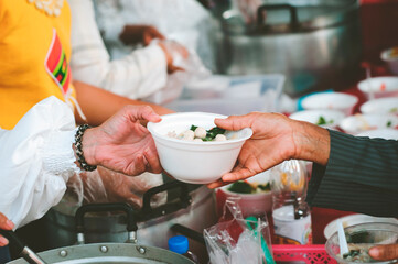 Volunteers scooping the food to share with the needy : concept of free food to beggars