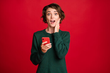 Photo of astonished lady arm on cheek open mouth impressed blog post isolated on red color background