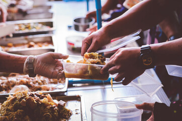 Providing free food to the poor : The hands of beggars receive donated food