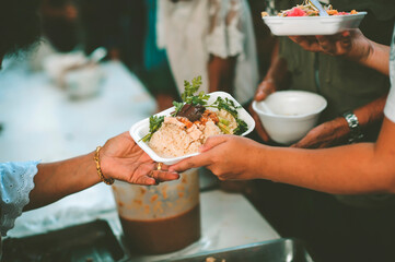 Providing free food to the poor : The hands of beggars receive donated food