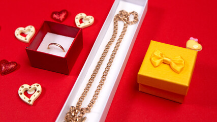 Colorful open box gift present golden bright wedding ring necklace marriage proposal on red background. Concept Valentine's Day. Love symbol jewelry, copy empty space for text, heart shape isolated