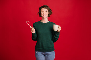 Portrait of attractive lady hold lollypop coffee toothy smile nice x-mas isolated on red color background