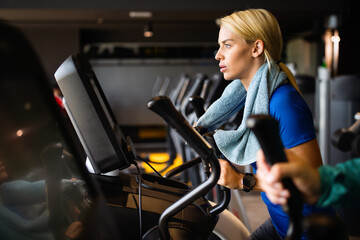Attractive fit young woman using a step machine in the gym