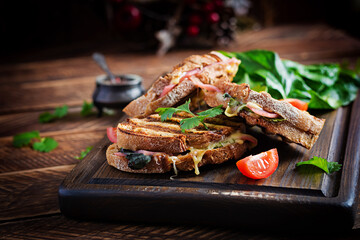 Grilled sandwich panini with ham, tomato, cheese and spinach. Delicious breakfast or snack. Copy space