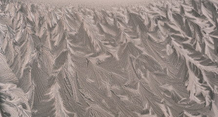 Frost drawing on window glass, snowflake ornament after anomaly ice cold. Blue top view