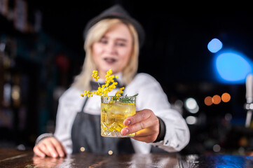 Girl bartender makes a cocktail at the bar