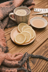 Natural remedies for flu lemon and honey with cup of hot tea on a wooden table