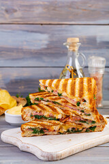 Club sandwich with ham, cheese, tomato, salad and chips