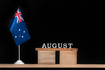 Wooden calendar of August with Australian flag on black background. Holidays of Australia in August.