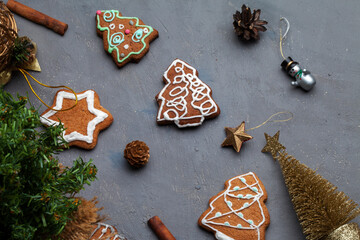 Fototapeta na wymiar Christmas holidays ornament flat lay; Christmas card background. Gingerbread cookie, christmas toys on gray background