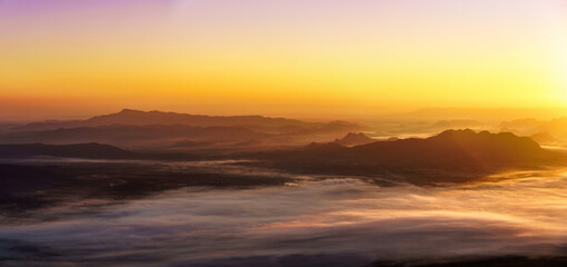 Fototapeta na wymiar Sunrise on the misty mountains background.