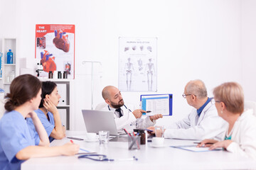 Teamwork of medical staff in hospital office talking about medicine technology. Clinic expert therapist discussing with colleagues about disease, medicine professional