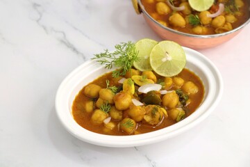 Indian food. Fresh chickpea masala, Chole masala curry, traditional north Indian dish. Popular Amritsari Chole bhature. Chana masala Garnished with lemon and onion. food photography. Copy space.
