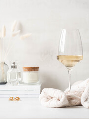Still life of glass of white wine, sweater and various items