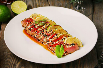 tuna steak with lime. sliced tuna steak in sesame on christmas background