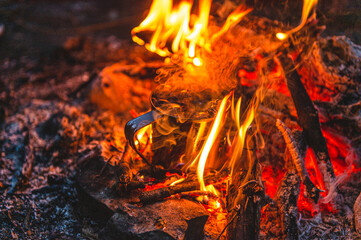 Close up of tea in metal mug heats up in bonfire