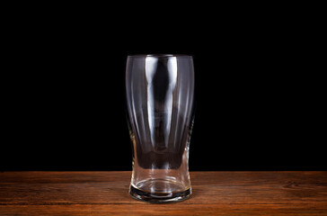 Beer glass on a wooden table isolated on a black background.  