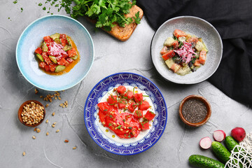 many salad on light concrete table top vie. ceviche with tuna, salmon and stracciatella with tomatoes and watermalone salad
