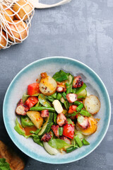 grilled octopus and potatoes top view. salad with octopus and ingredients on table top view
