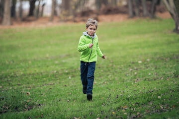 Young boy runing in the old orchard.