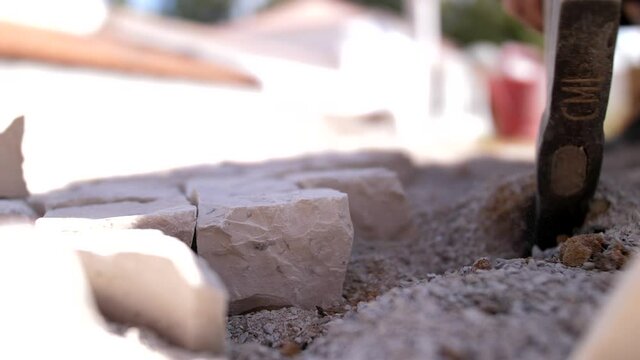 paver working on traditional portuguese cobblestone pavement 4k