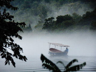 man driving boat on the river through fog in canyon cetina