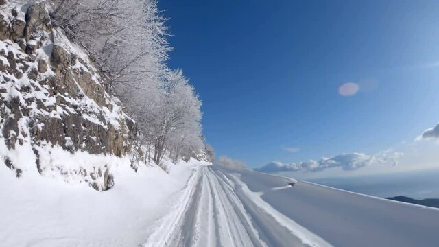 Driving POV of snow covered closed mountain road. Natural background.
