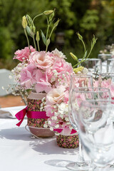 Wedding table decorated with bouquet of pink flowers and wine glasses.