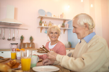 Fototapeta na wymiar Elderly couple having breafast and looking happy