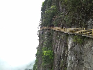 People on a cat walk on a cliff, Yichun, Ming Yue Mountains, China.