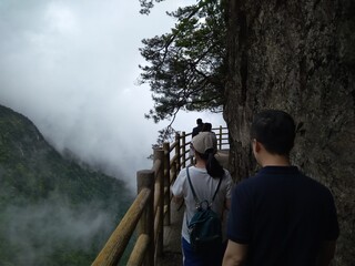 People on a cat walk on a cliff, Yichun, Ming Yue Mountains, China.