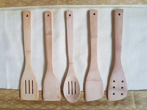 Wooden Spatula And Natural Wood Ladle On A Golden Silk Background.