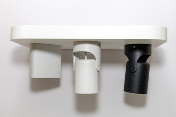 Three turned off modern metal led lamp on the white color wall. Free space.