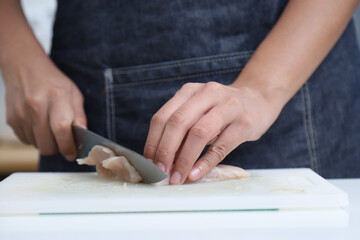 Woman hands cutting chicken in the kitchen. Chef cooking Chef preparing chicken at kitchen