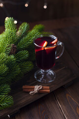 Christmas drink. Sangria or mulled wine on wooden background with christmas lights and fir branches. Copy space