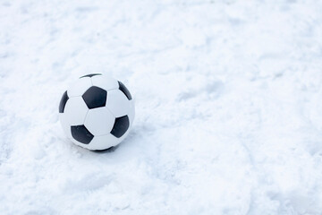 The classic soccer ball scores a goal. Football in the winter outdoors in snowy weather. Outdoor...
