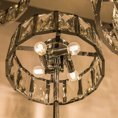 Close up of the glowing luxury expensive lamp from a crystal ceiling lampshade. Classic style in a...