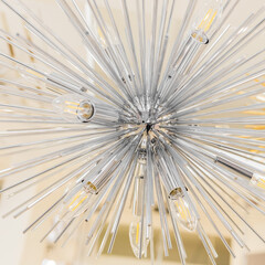 Close-up of a switched off incandescent lamp in a ceiling with a clear glass chandelier in the form of a modern style tube. Inside.