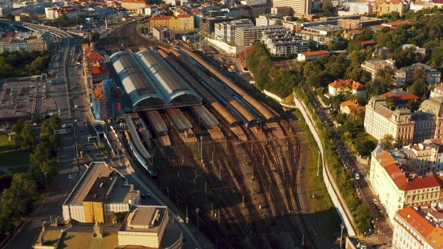 Drone overPrague main train station railroad tracks branching of into different rail sections, aerial tilting up to show surrounding landscape of railways