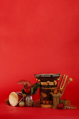 christmas and new year background for musician. musician percussion instruments and christmas tree toys on red background vertical orientation