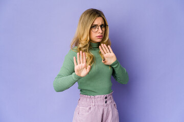 Young caucasian blonde woman rejecting someone showing a gesture of disgust.