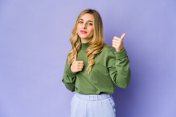 Young caucasian blonde woman raising both thumbs up, smiling and confident.