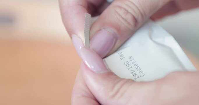 Woman's Hand Tearing Off The Packaging Of Antigen Rapid Test Cassette Kit For COVID-19. - close up shot