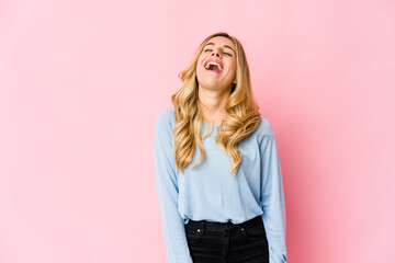 Young caucasian blonde woman indicates with both fore fingers up showing a blank space.