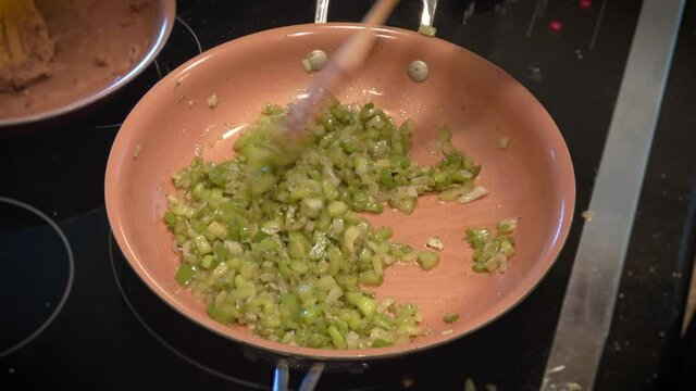 Woman Sautes Celery And Onion On Induction Stove Top For Stuffing, Overhead Close Up // 4K