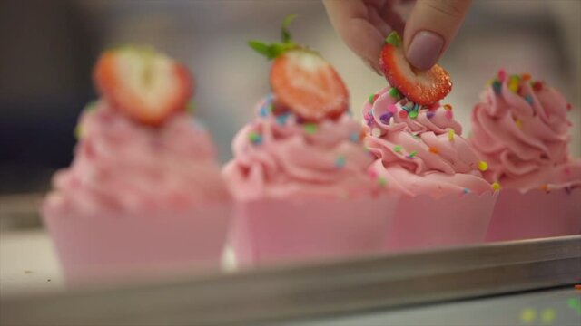 Close-Up Shot Of Putting Strawberries On Muffins