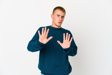 Young caucasian handsome man rejecting someone showing a gesture of disgust.