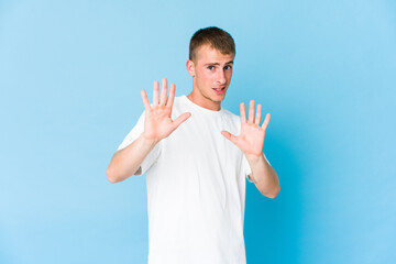 Young caucasian handsome man rejecting someone showing a gesture of disgust.