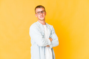 Young caucasian handsome man who feels confident, crossing arms with determination.